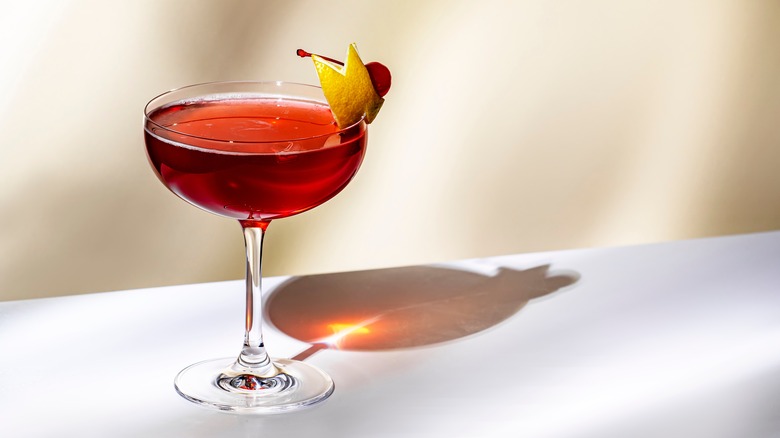 Whiskey cocktail with a lemon and cherry garnish