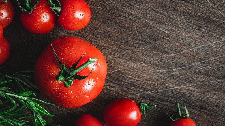 Whole tomatoes on wooden board