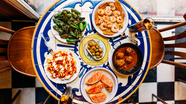 Table filled with various types of Spanish tapas dishes