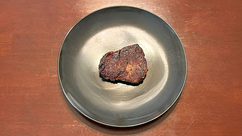 Longhorn Steakhouse filet on a black plate atop a wood surface