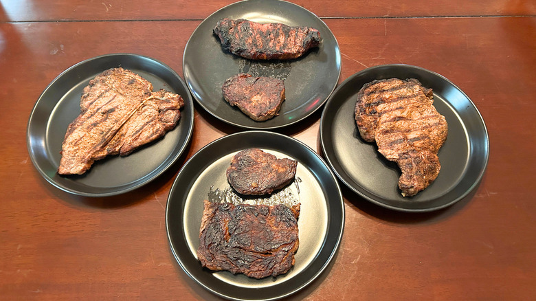 Six Longhorn Steakhouse steaks on black plates