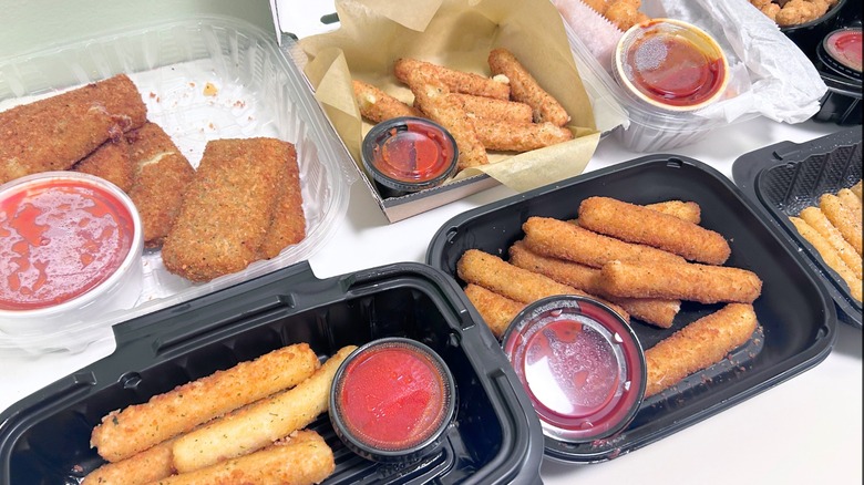 Seven chain restaurant mozzarella sticks together on a green and white background