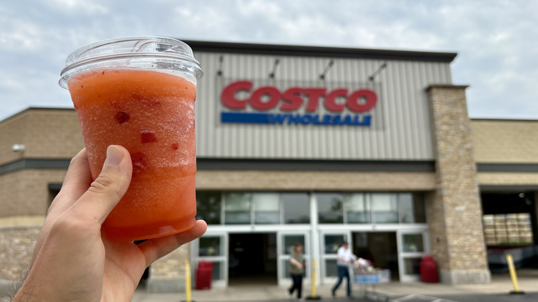 hand holding frozen strawberry lemonade next to Costco sign