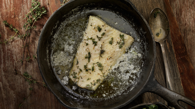Halibut filet poaching in cast iron pan