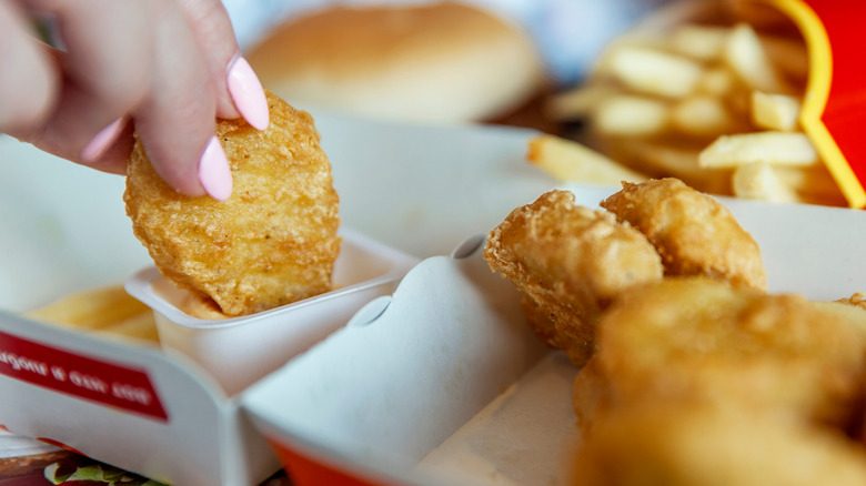 McDonald's chicken nuggets dipped in sauce with fries