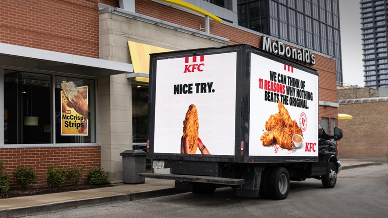 KFC truck in front of McDonald's touting that it makes better chicken tenders