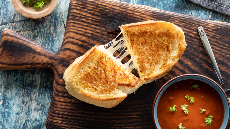 grilled cheese sandwich cut in half with a bowl of tomato soup