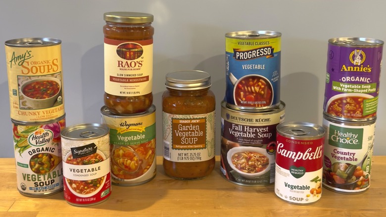 Variety of canned store-bought soups on a wooden table