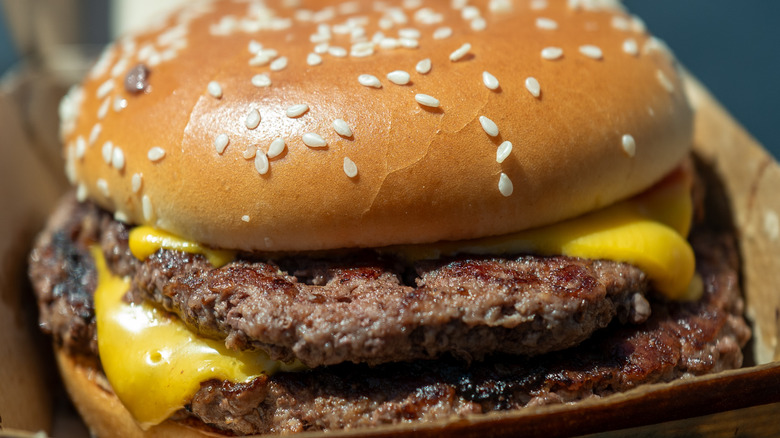 Closeup of a McDonald's Double Quarter Pounder with cheese, in an open brown takeout box