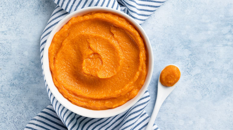 butternut squash puree in bowl on striped napkin over mottled blue counter