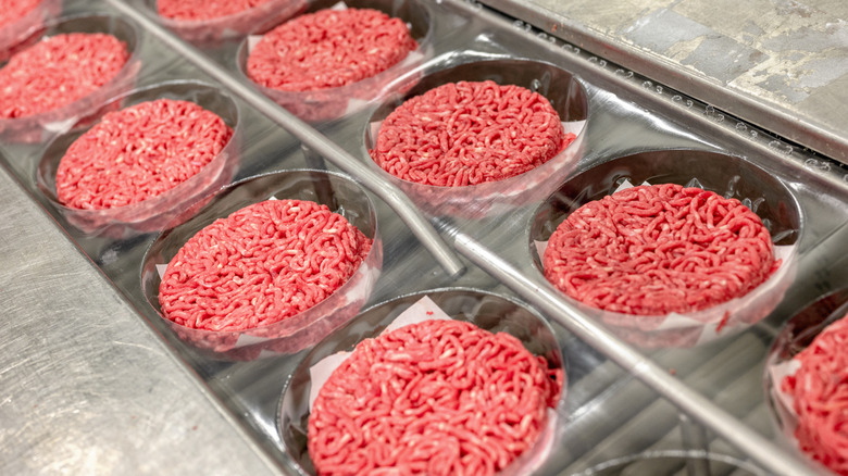 ground beef patties on a factory sorting line
