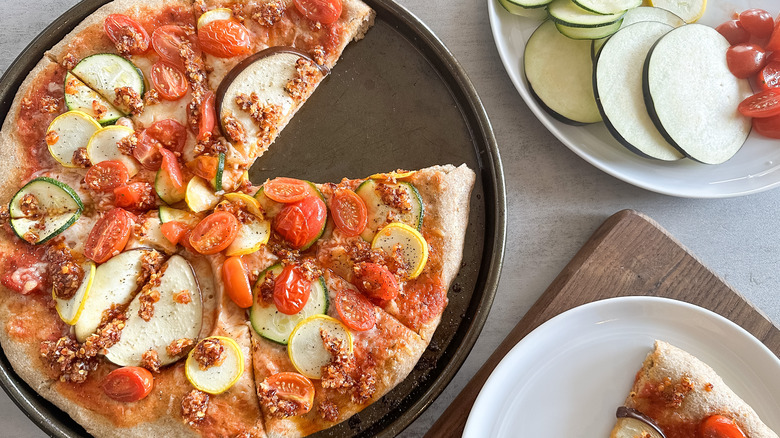 sliced summer vegetable pizza with chili onion crisp